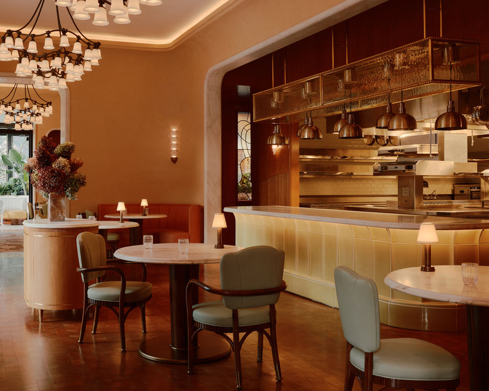 NEOZ Victoria cordless table lamp in aged brass finish illuminating a table setting at Mamani in Dallas.